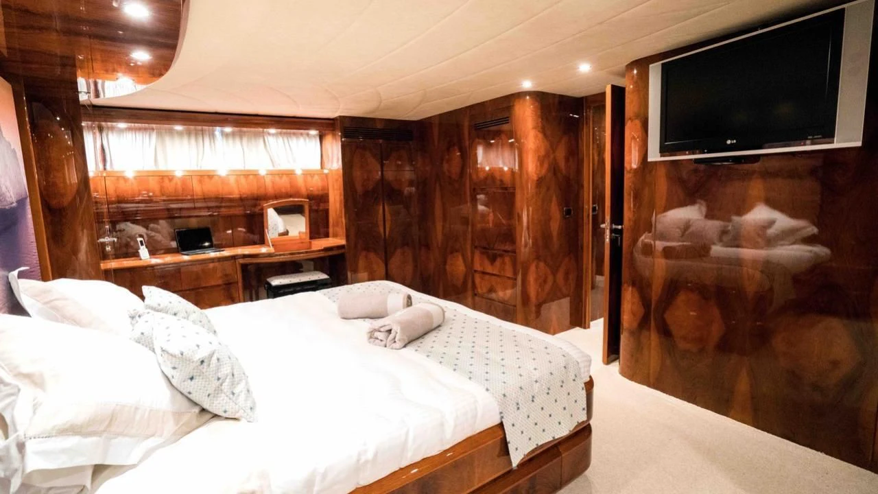 a room with a bed and a television aboard B5 Yacht for Sale