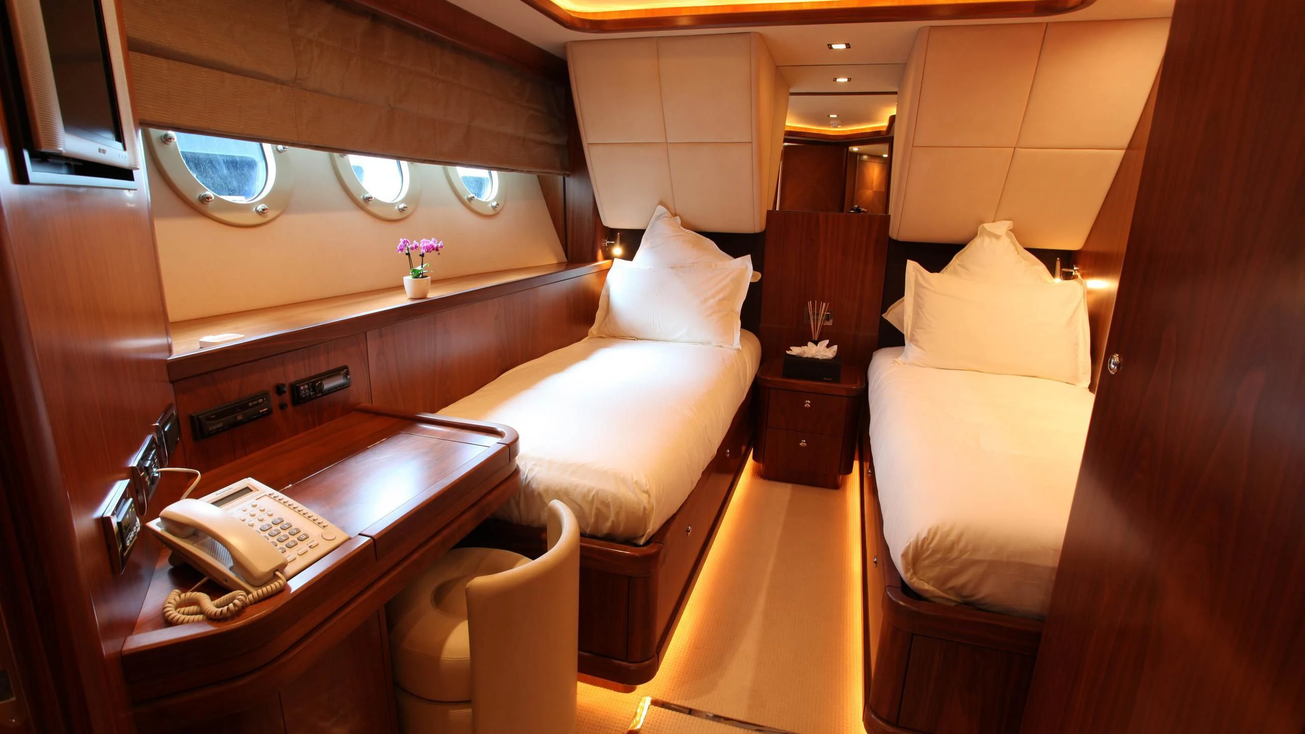 a room with beds and a phone aboard KEFI Yacht for Charter