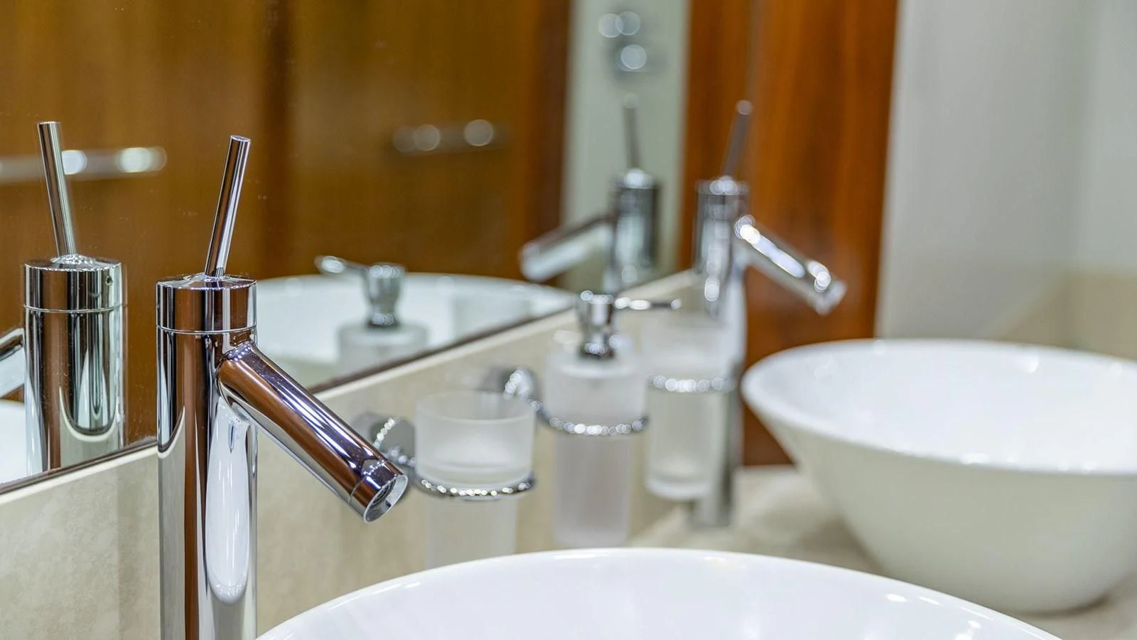 a bathroom sink with a faucet and a mirror aboard KEFI Yacht for Charter