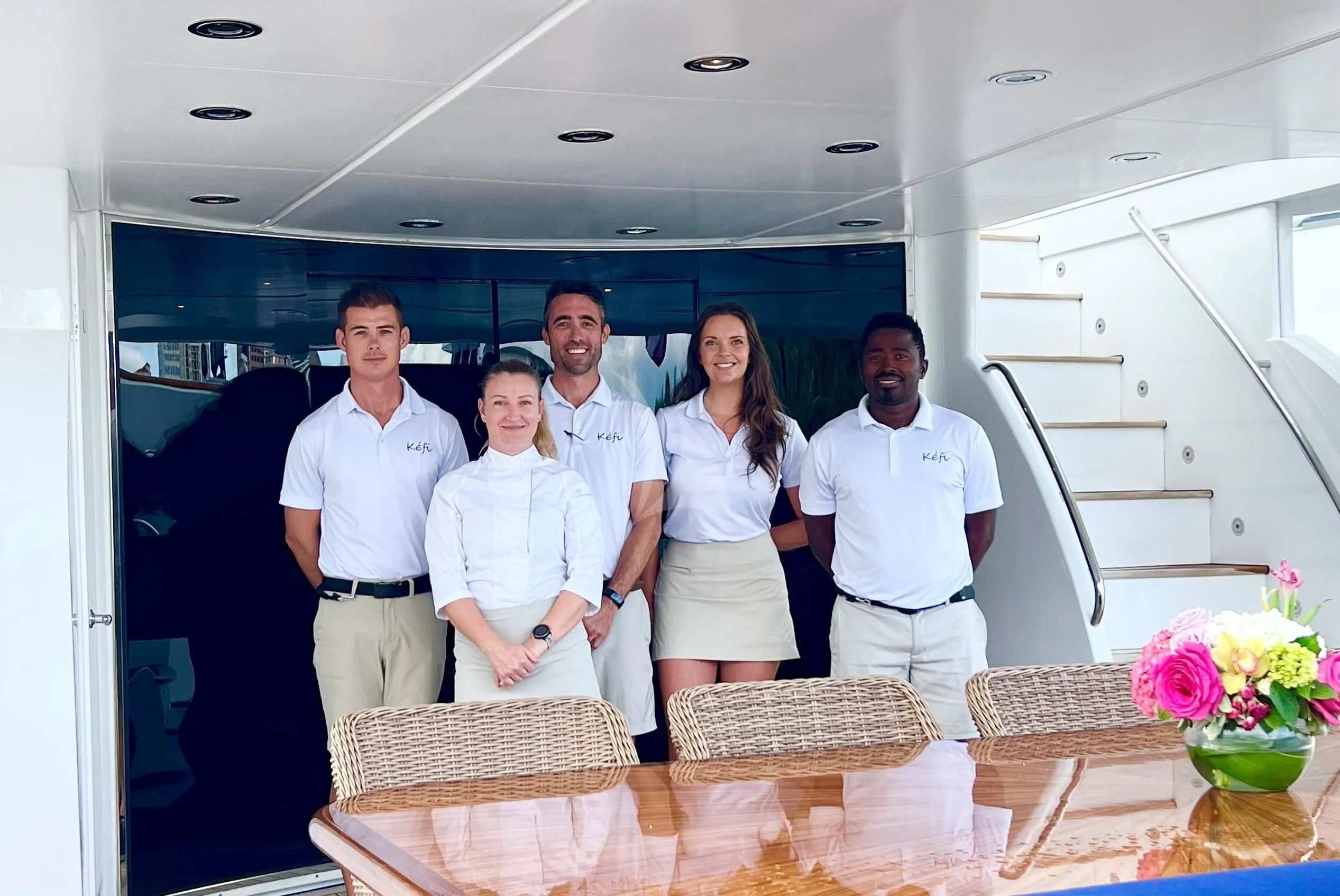 a group of people posing for a photo aboard KEFI Yacht for Charter