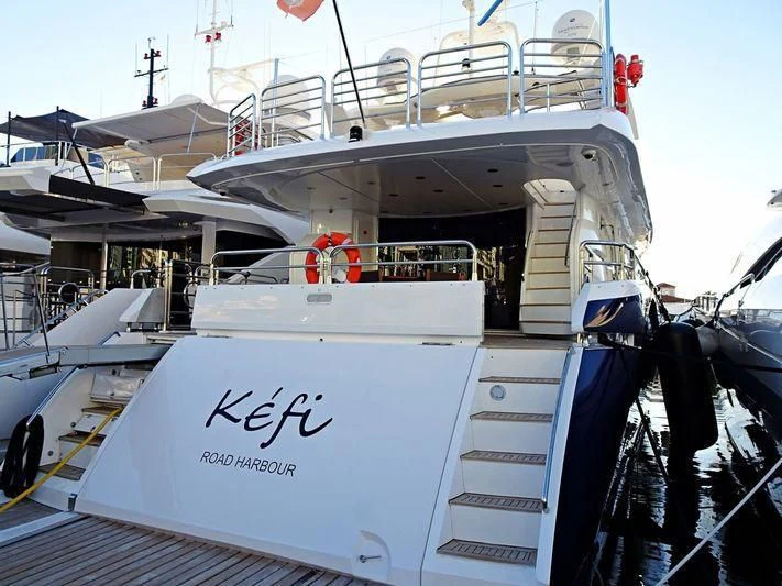 a large white boat with a red stripe on the front aboard KEFI Yacht for Charter