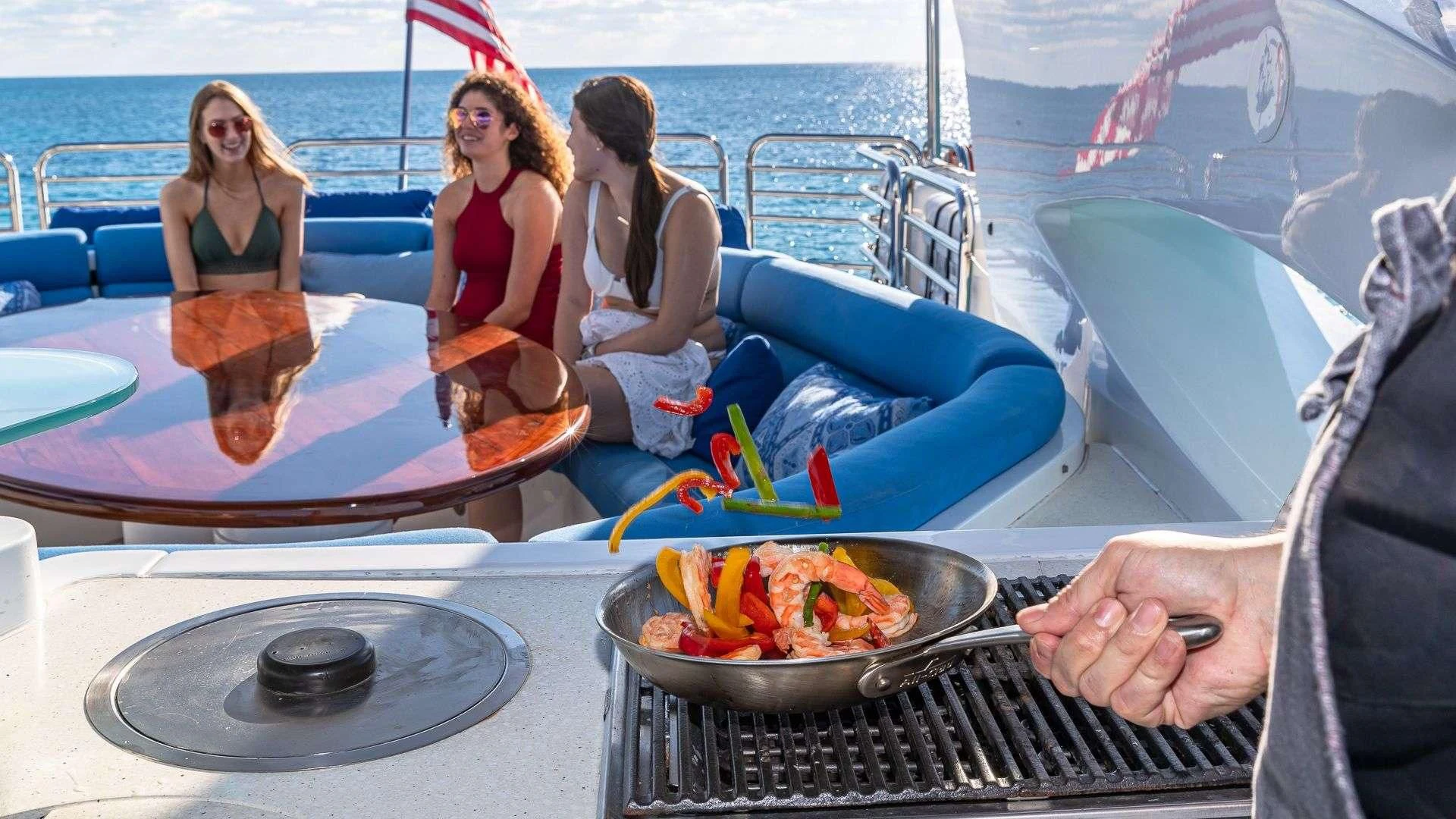 a group of women sitting on a boat with a bowl of food aboard KEFI Yacht for Charter