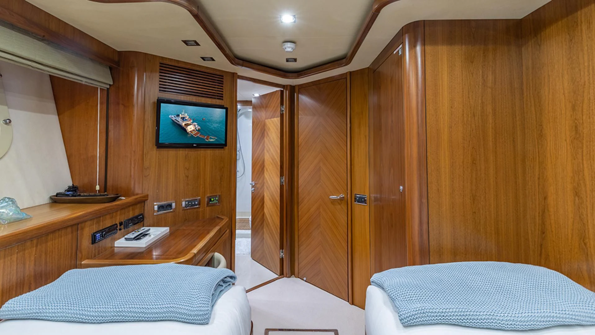 a room with a bed and a television aboard KEFI Yacht for Charter