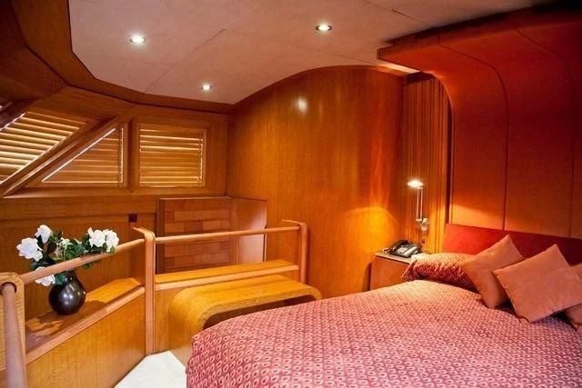 a bed with a flower vase on it aboard MARANATHA Yacht for Sale