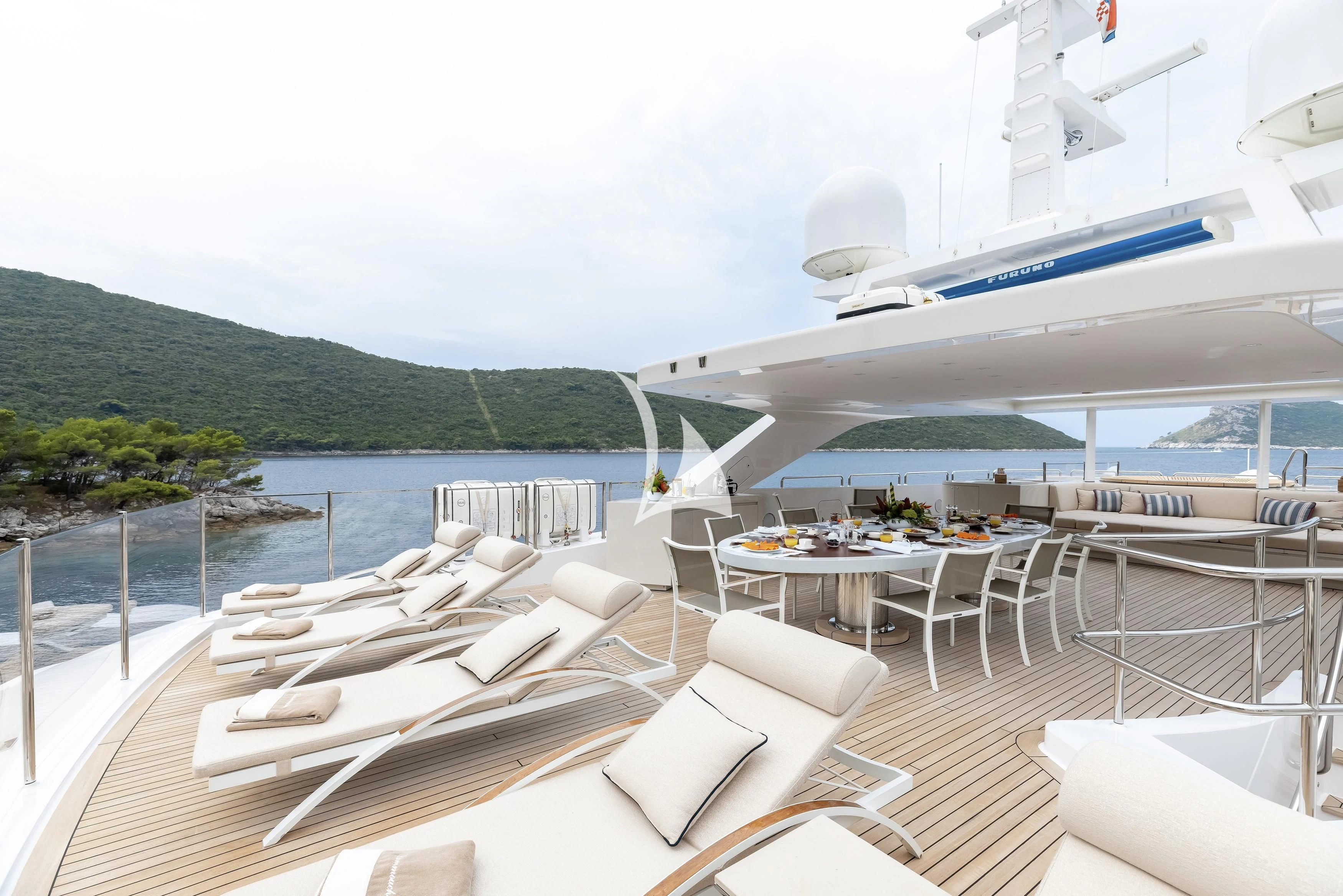 a deck with chairs and tables on it and a plane in the background aboard LAMMOUCHE Yacht for Sale