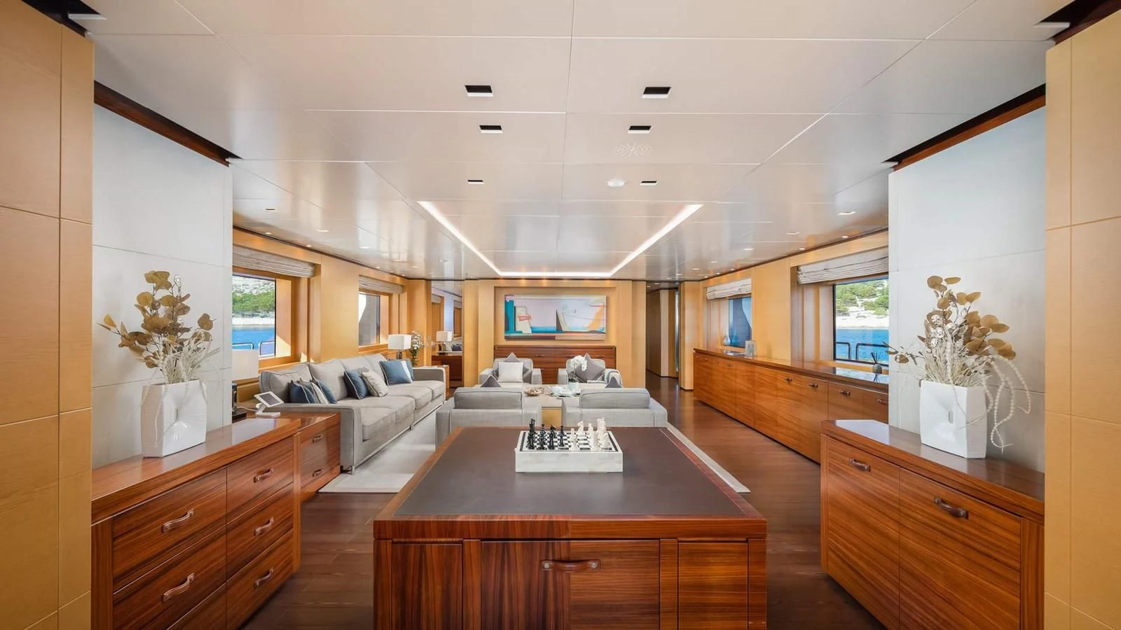 a living room with a table and couches aboard LAMMOUCHE Yacht for Sale
