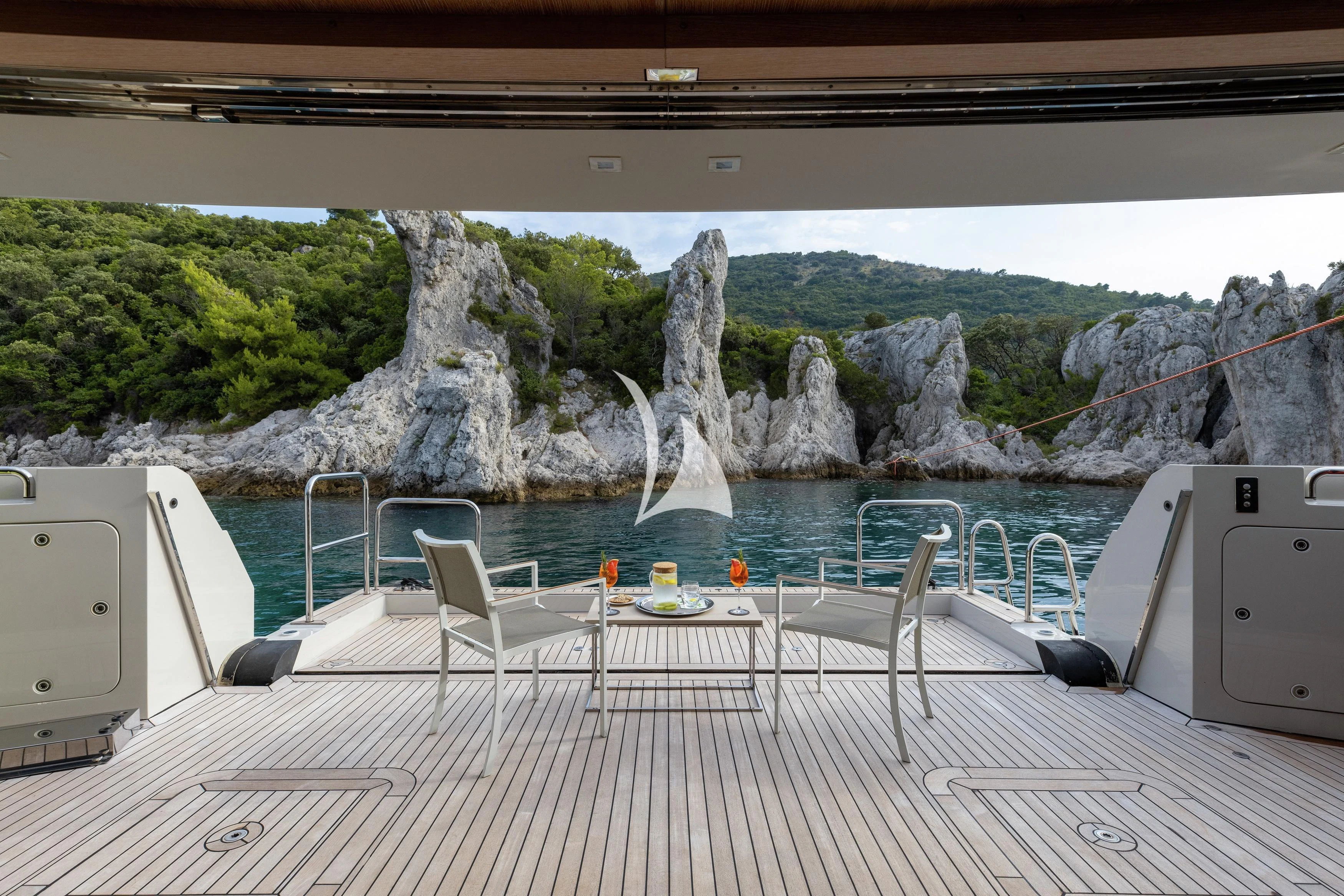 a deck with a table and chairs on it aboard LAMMOUCHE Yacht for Sale