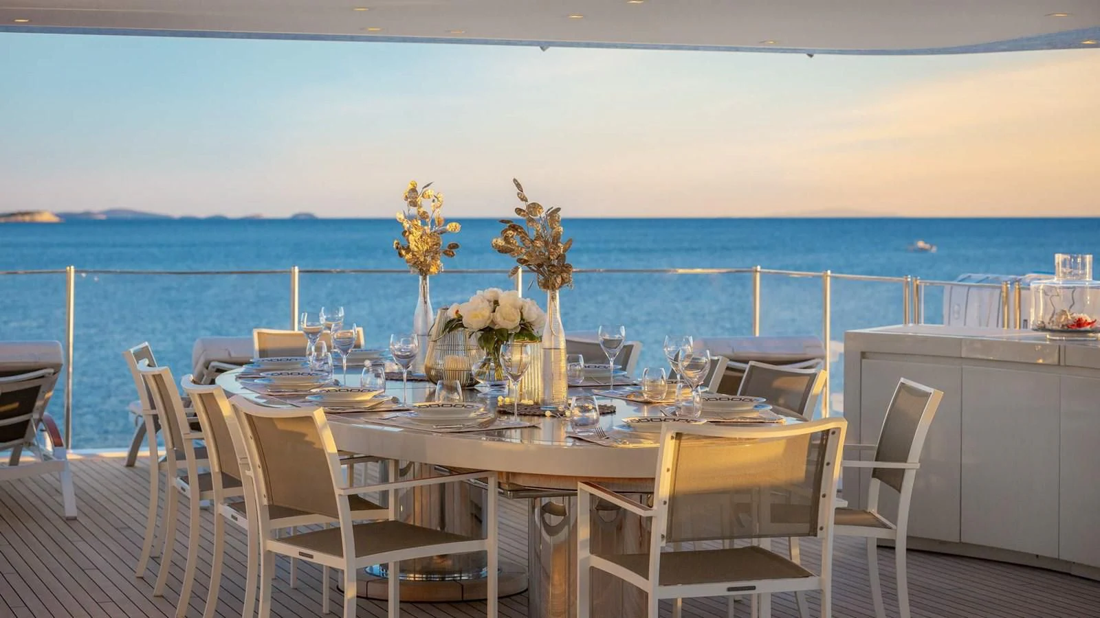 a table set for a dinner on a balcony overlooking the ocean aboard LAMMOUCHE Yacht for Sale