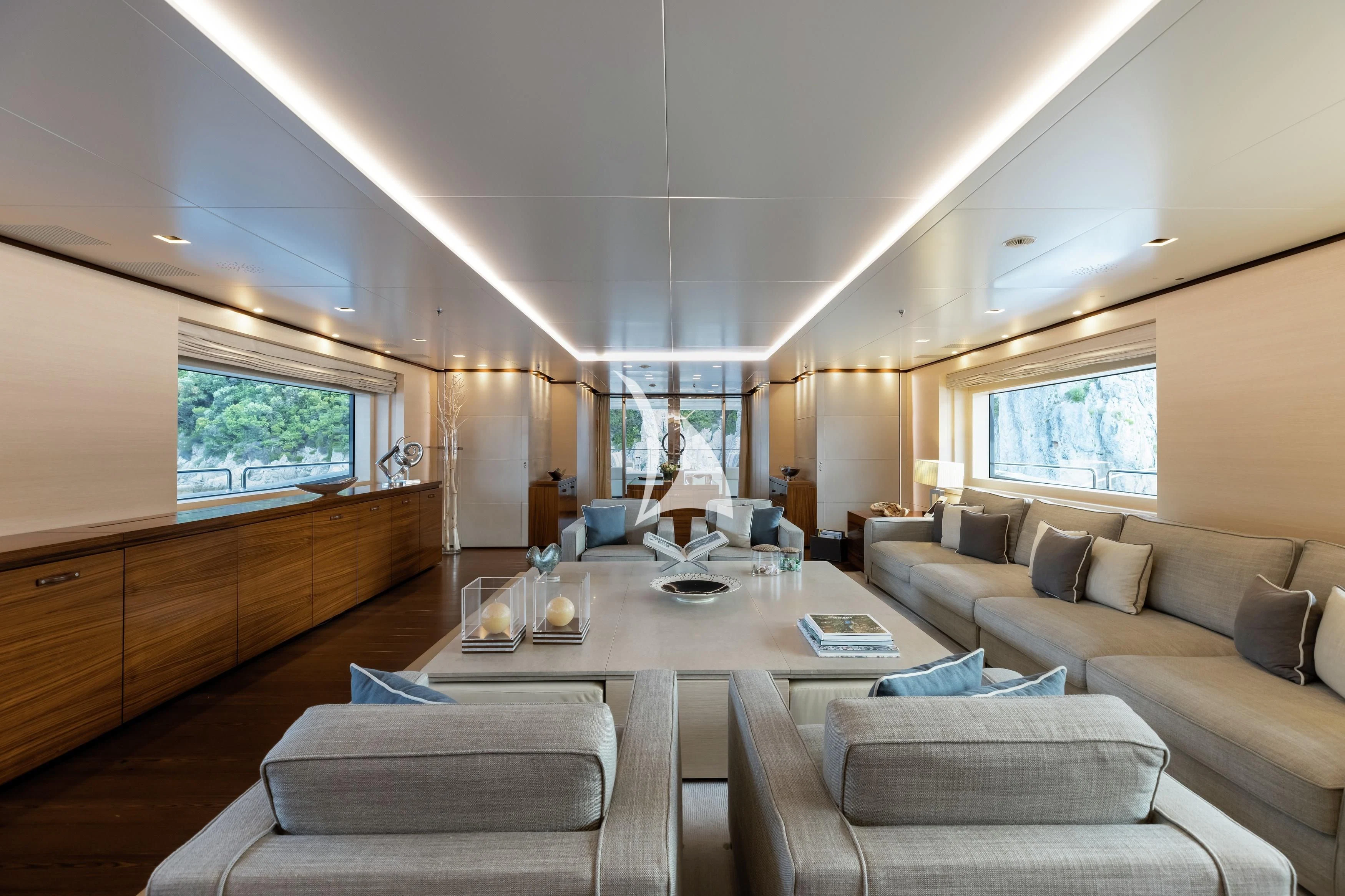 a living room with a table and couches aboard LAMMOUCHE Yacht for Sale