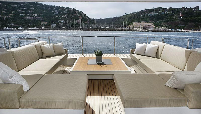 a table with plants on it next to a couch and a large body of water aboard LAMMOUCHE Yacht for Sale