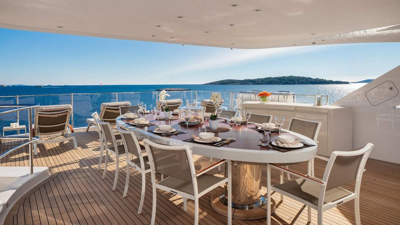 a table set for a meal on a deck overlooking the ocean aboard LAMMOUCHE Yacht for Sale