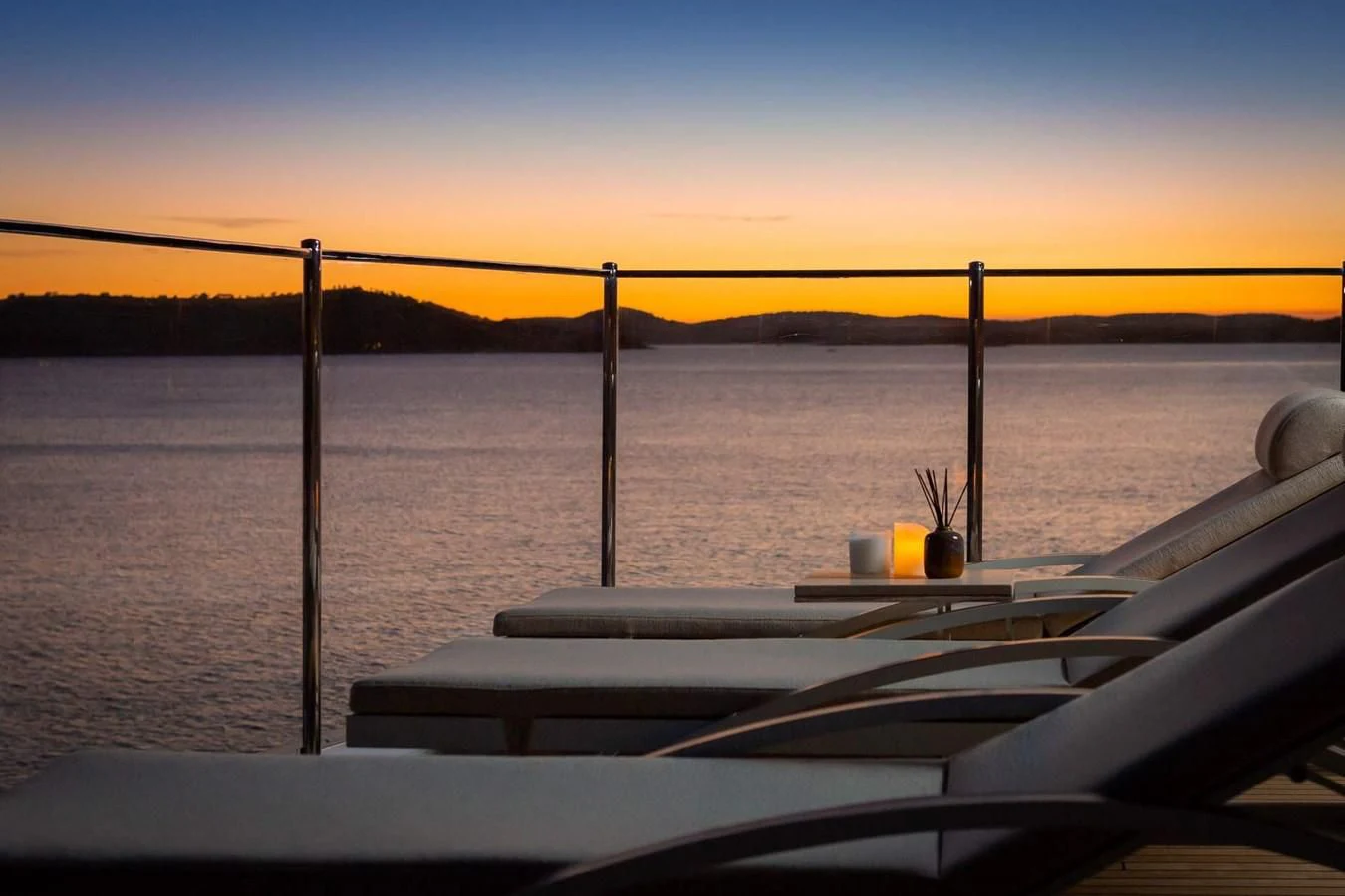a deck with a view of a sunset and a body of water aboard LAMMOUCHE Yacht for Sale