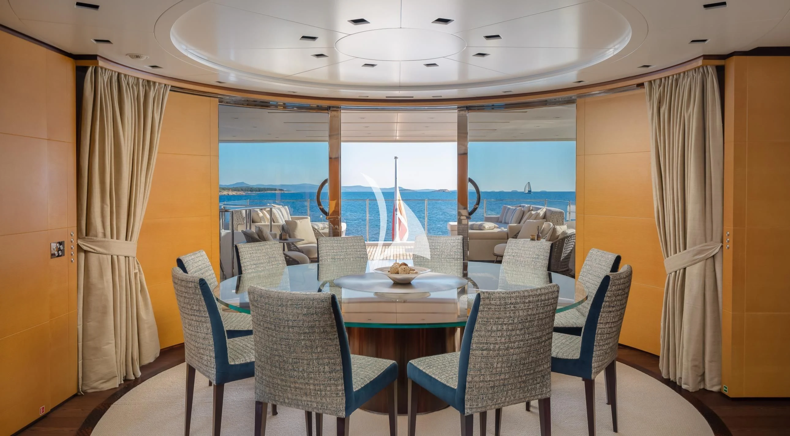 a dining room with a view of the ocean aboard LAMMOUCHE Yacht for Sale