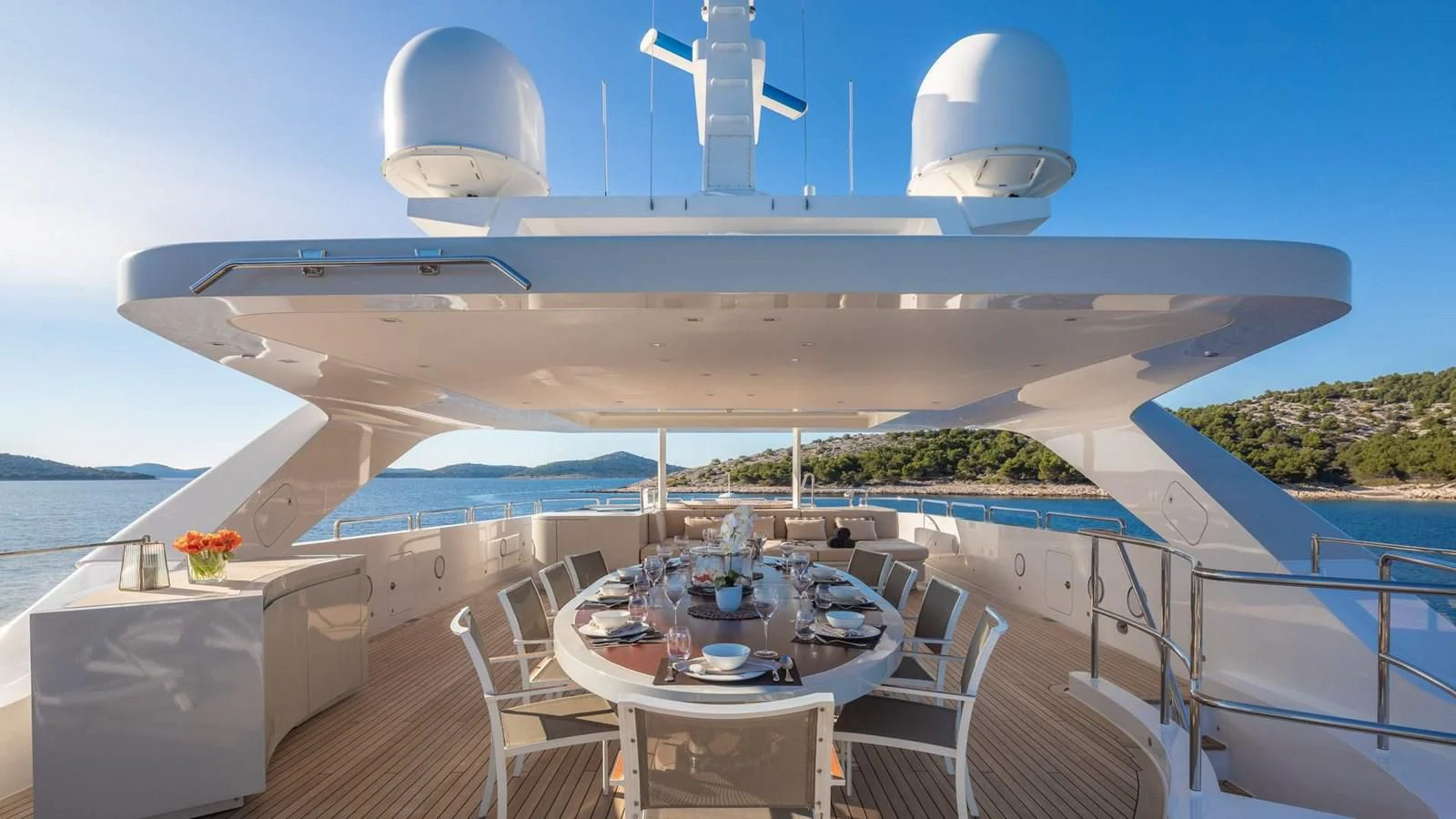 a large white ship with a table and chairs on a deck aboard LAMMOUCHE Yacht for Sale