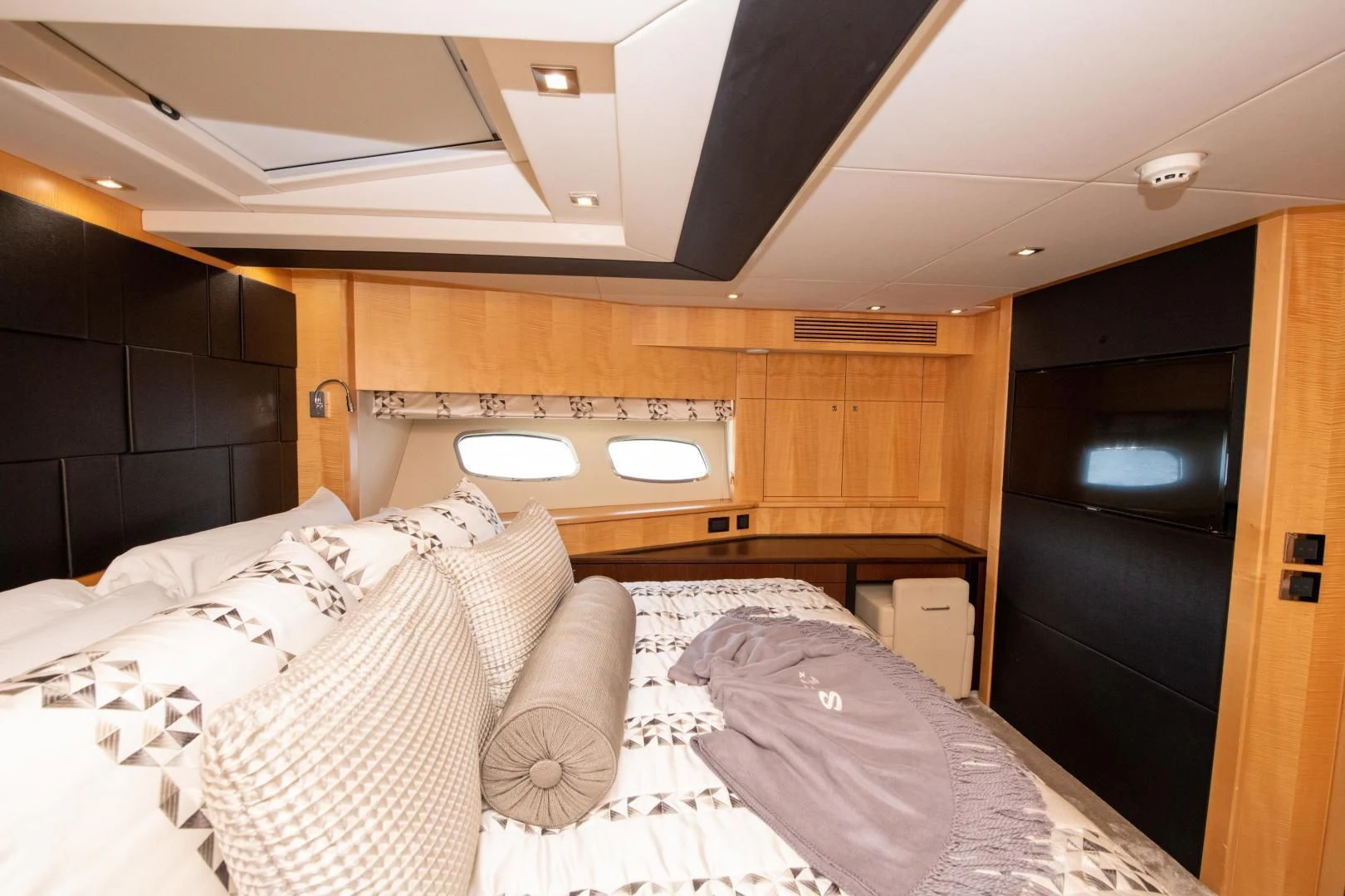 a bedroom with a bed and a wood cabinet aboard FUNSEEKER Yacht for Sale