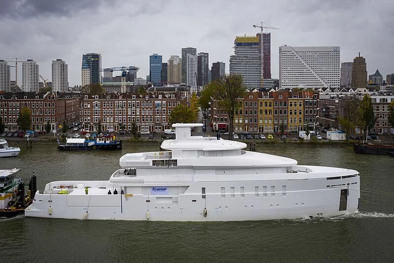 a large white boat in a harbor aboard SHINKAI Yacht for Sale