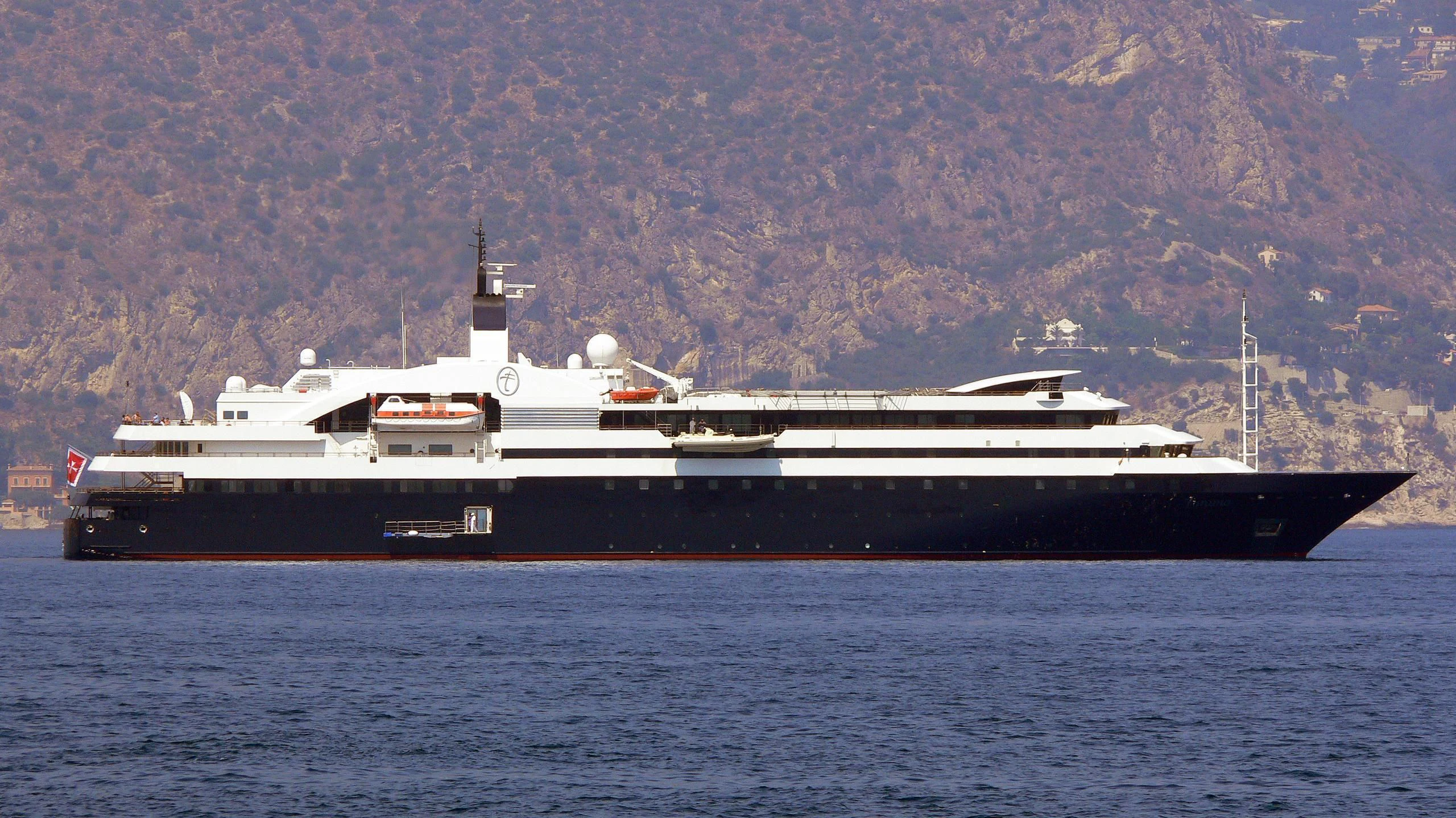 a large ship in the water aboard TURAMA Yacht for Sale