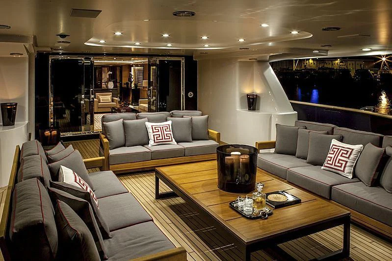 a living room with a large glass coffee table and a large window aboard ALASKA Yacht for Sale