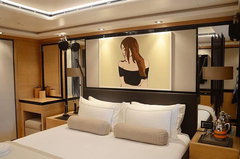a large bed with a painting on the wall aboard ALASKA Yacht for Sale