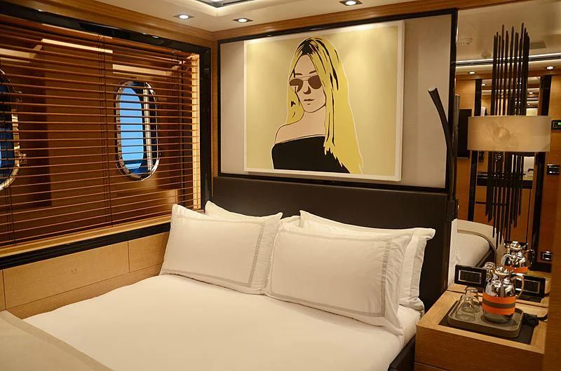 a bed with a painting on the wall aboard ALASKA Yacht for Sale