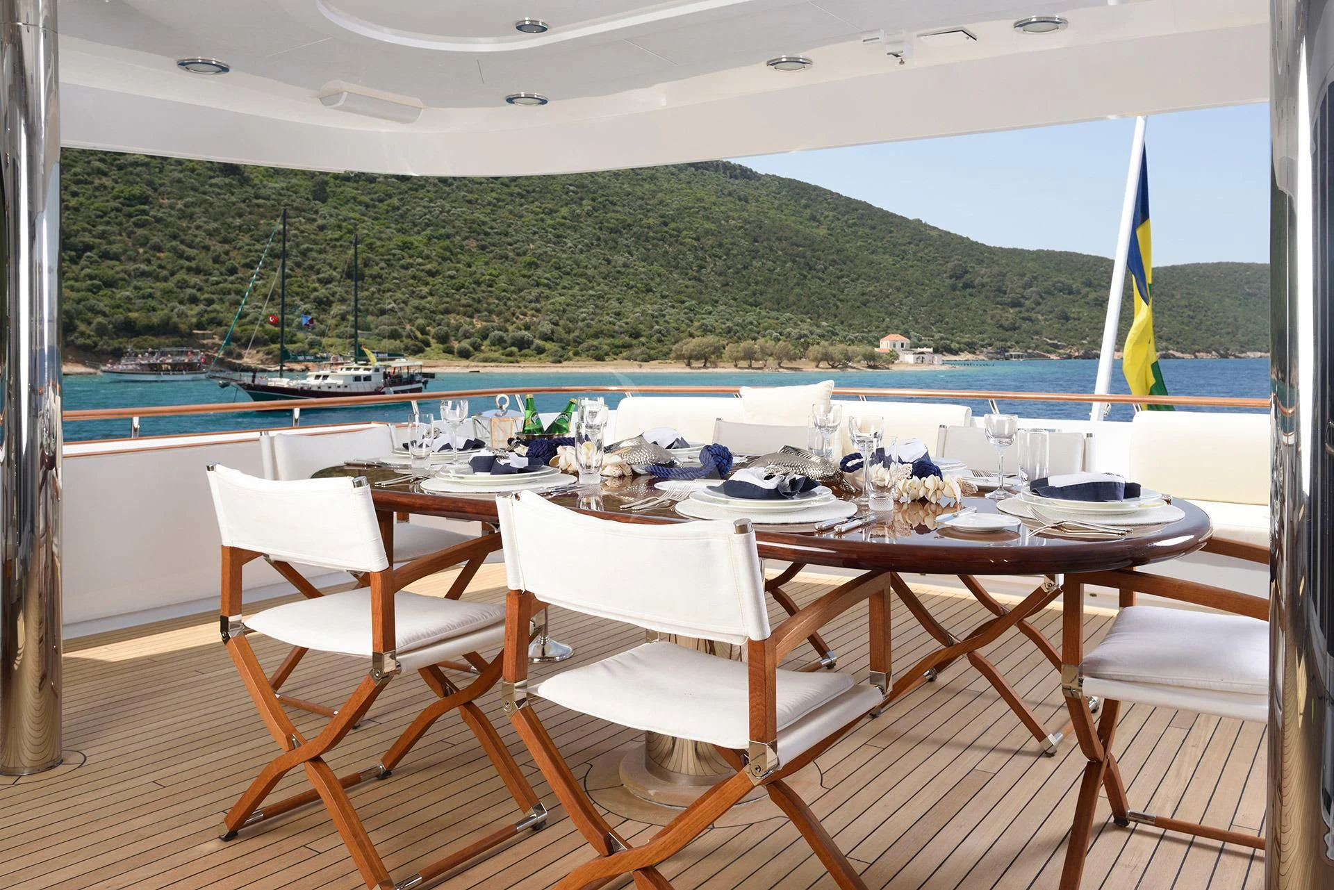 a table and chairs on a deck overlooking a body of water aboard AZZURRA II Yacht for Sale