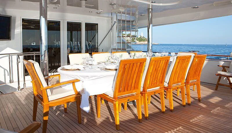 a table and chairs on a deck aboard AZZURRA II Yacht for Sale