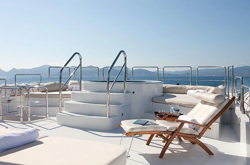 a room with a bed and chairs aboard AZZURRA II Yacht for Sale