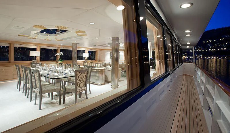 a long table with chairs and a large mirror in a room with a large window aboard AZZURRA II Yacht for Sale