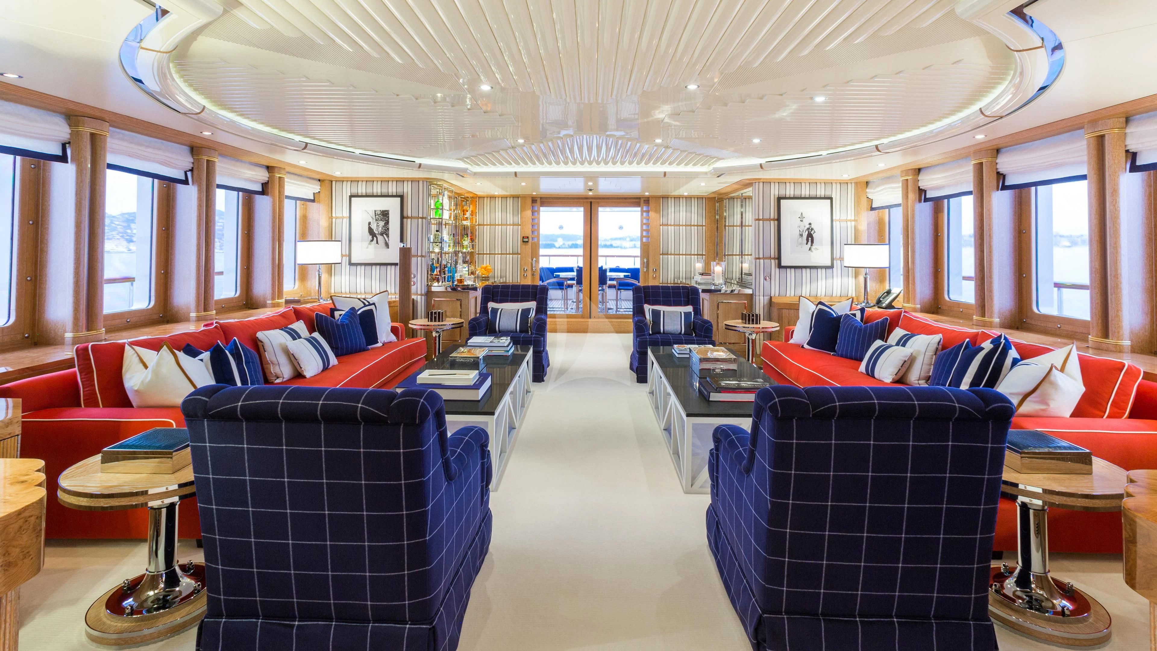 a large living room with blue chairs aboard AIR Yacht for Sale