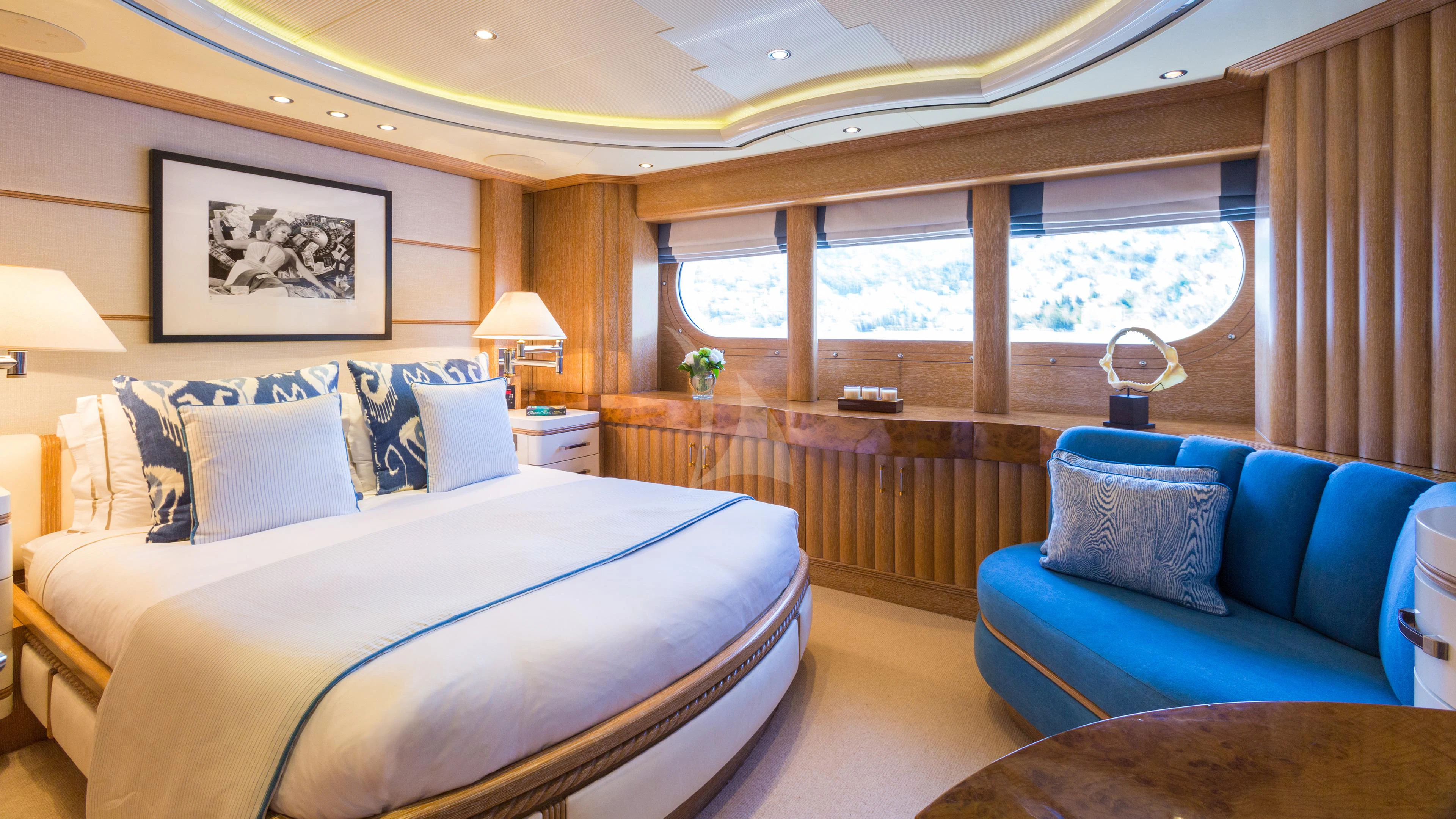 a large bedroom with a blue couch aboard AIR Yacht for Sale