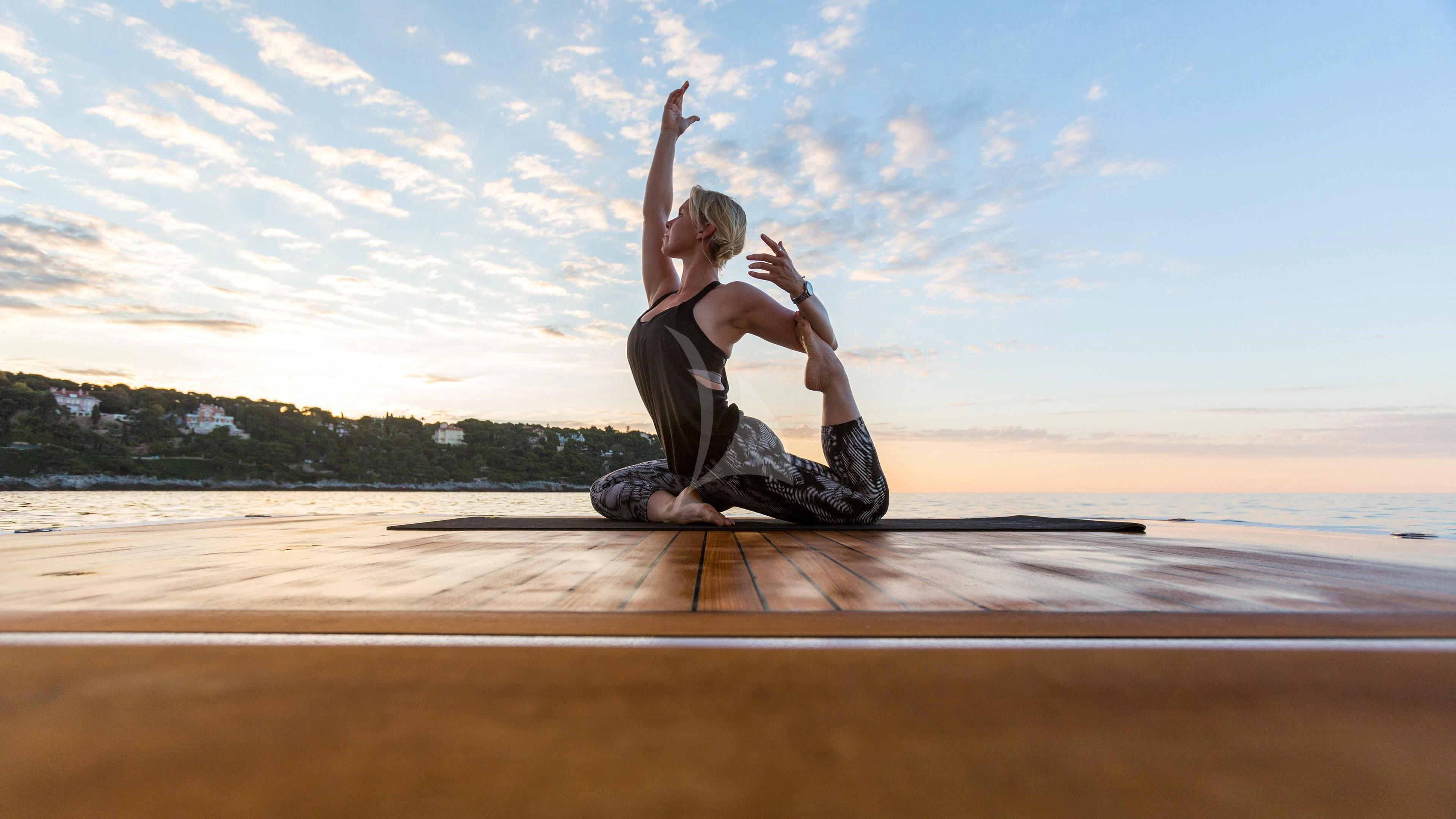 a man doing yoga on a beach aboard AIR Yacht for Sale