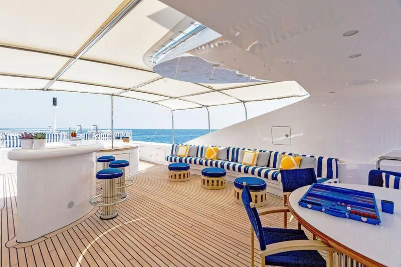 a room with a deck and chairs aboard AIR Yacht for Sale