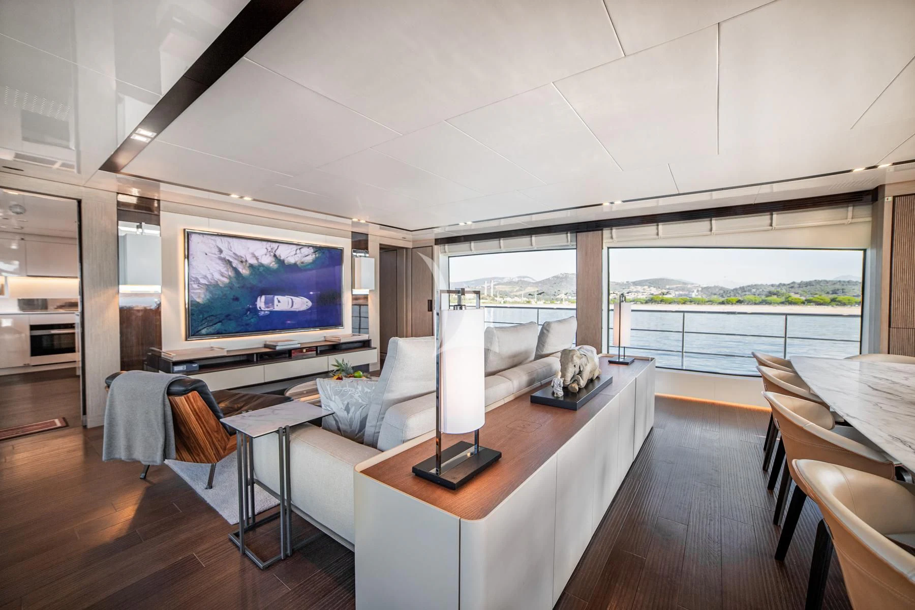 a room with a large flat screen television and a table with chairs aboard EDEN Yacht for Sale