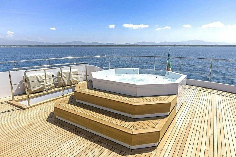 a deck with a view of the ocean and mountains in the background aboard EDEN Yacht for Sale