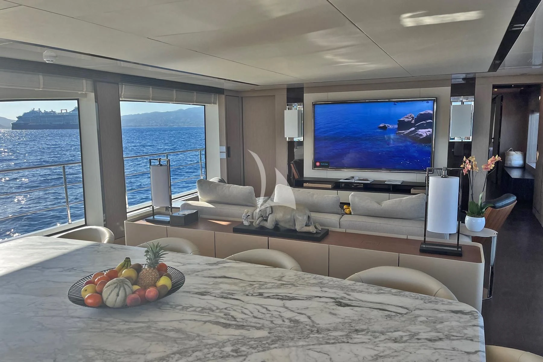 a large flat screen television in a room with a large window aboard EDEN Yacht for Sale