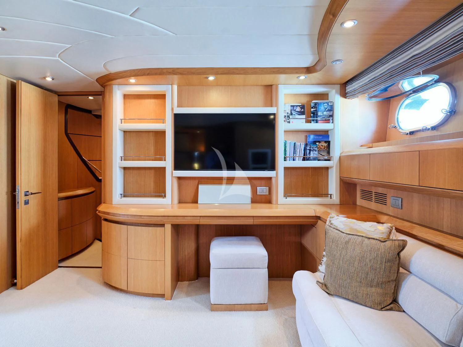 a room with a couch and a shelf with books on it aboard ANASA Yacht for Sale