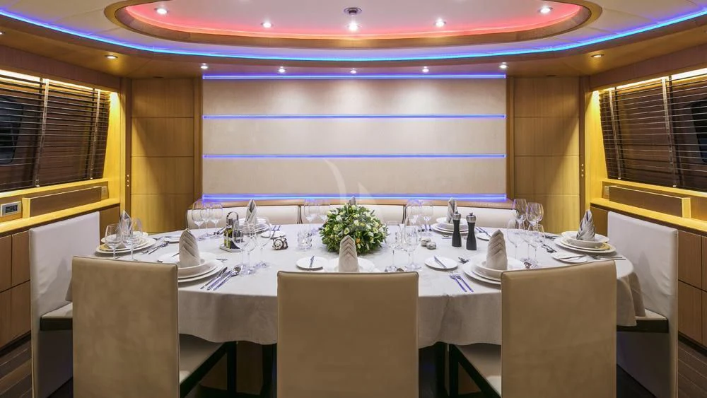 a room with tables and chairs aboard ANASA Yacht for Sale