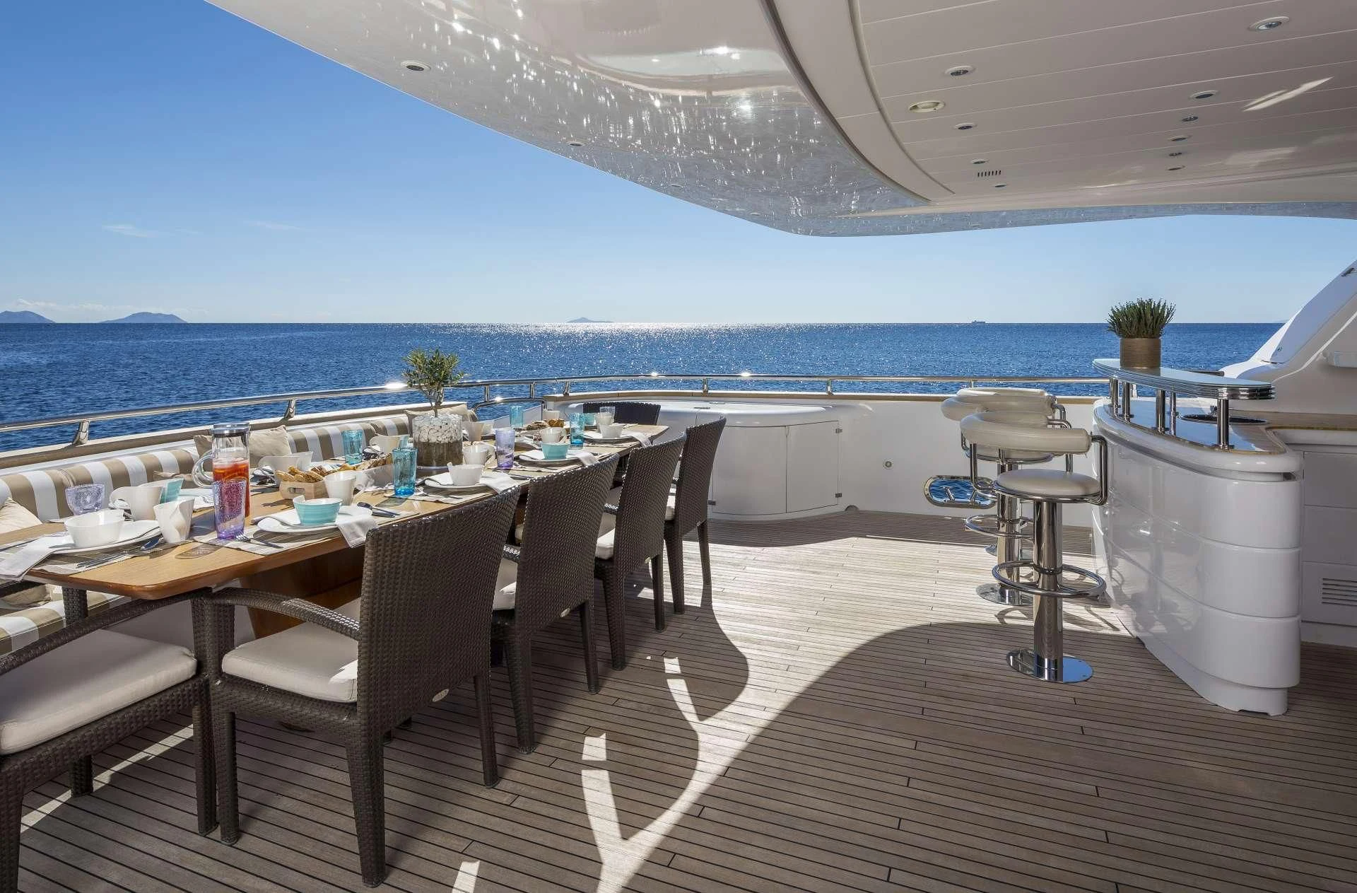 a table set for a meal on a deck overlooking the ocean aboard ANASA Yacht for Sale
