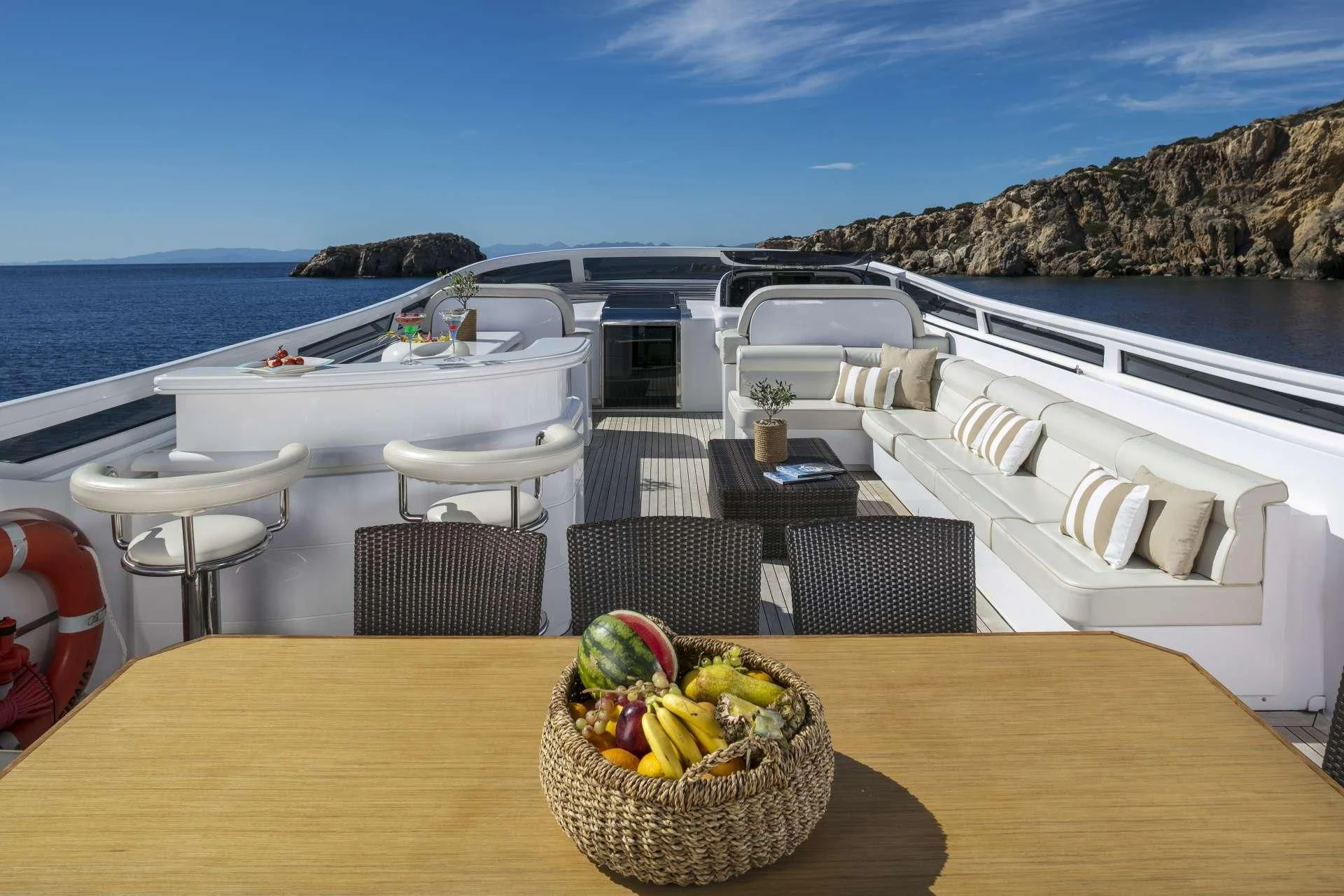 a table with chairs and a basket of fruit on it aboard ANASA Yacht for Sale