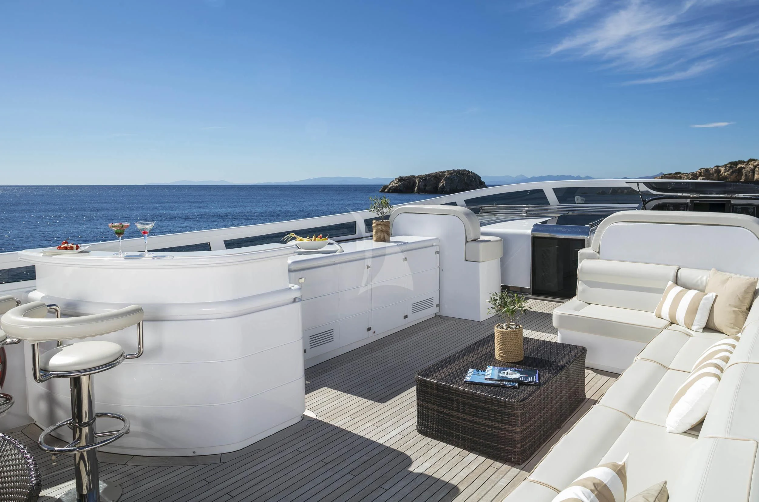 a white lounge chair next to a white sofa and a large body of water aboard ANASA Yacht for Sale
