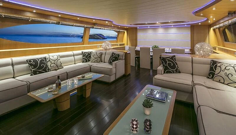 a living room with a large sofa and a coffee table aboard ANASA Yacht for Sale