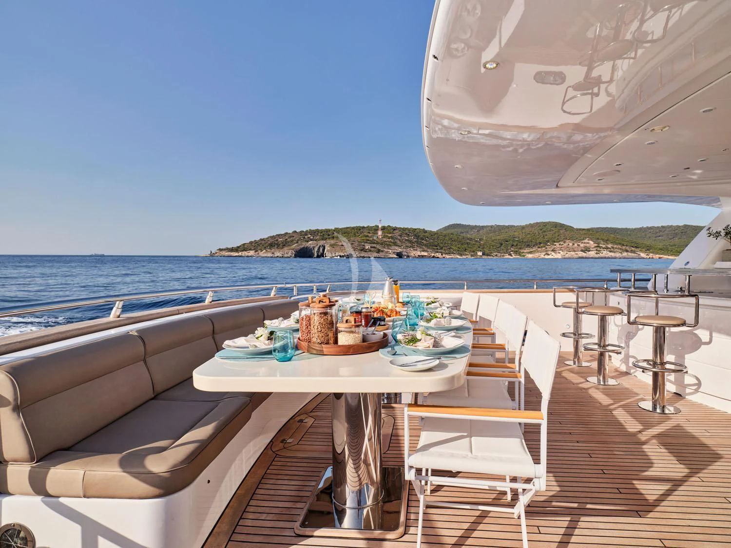 a table on a deck overlooking the ocean aboard ANASA Yacht for Sale