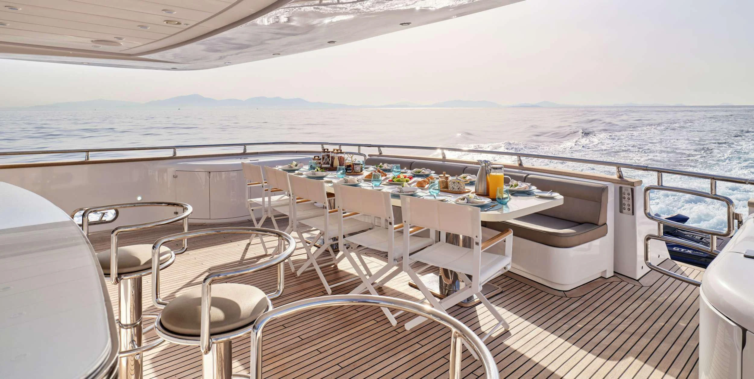 a large white patio with a table and chairs on it aboard ANASA Yacht for Sale