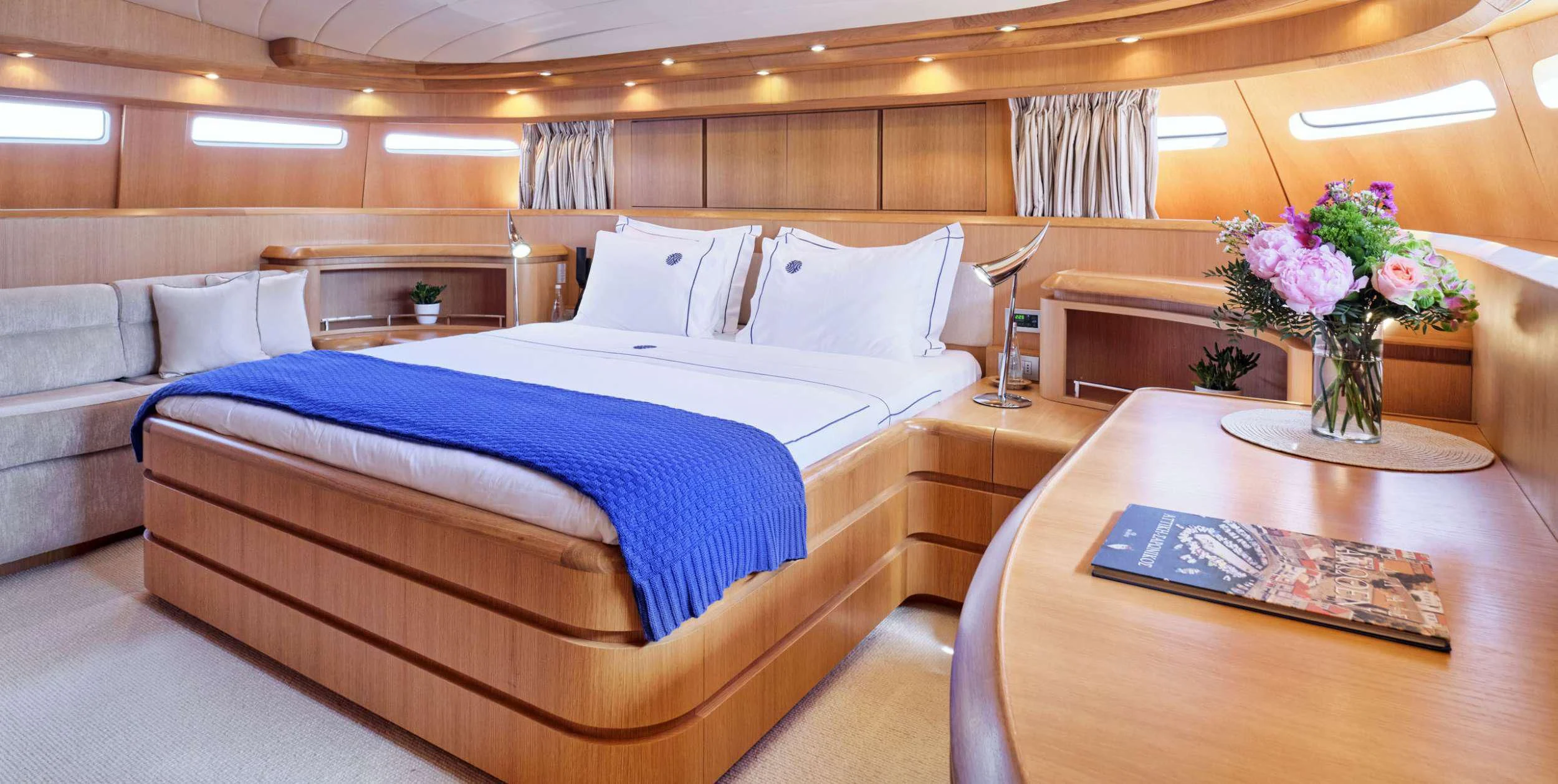 a bed with a blue sheet and white pillows aboard ANASA Yacht for Sale