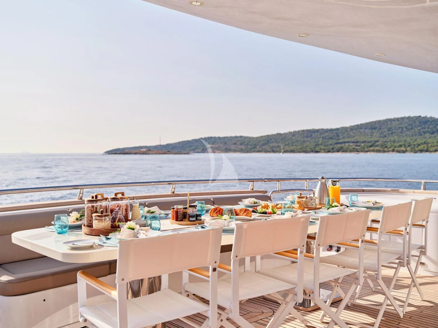 a table set for a meal on a balcony overlooking a large body of water aboard ANASA Yacht for Sale