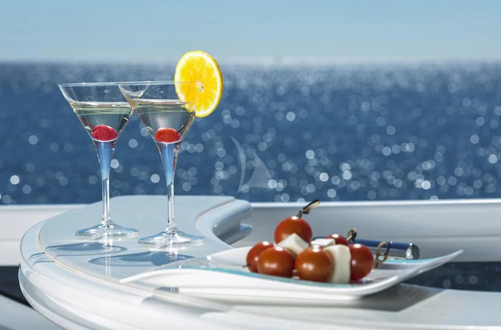 a plate of food and glasses aboard ANASA Yacht for Sale