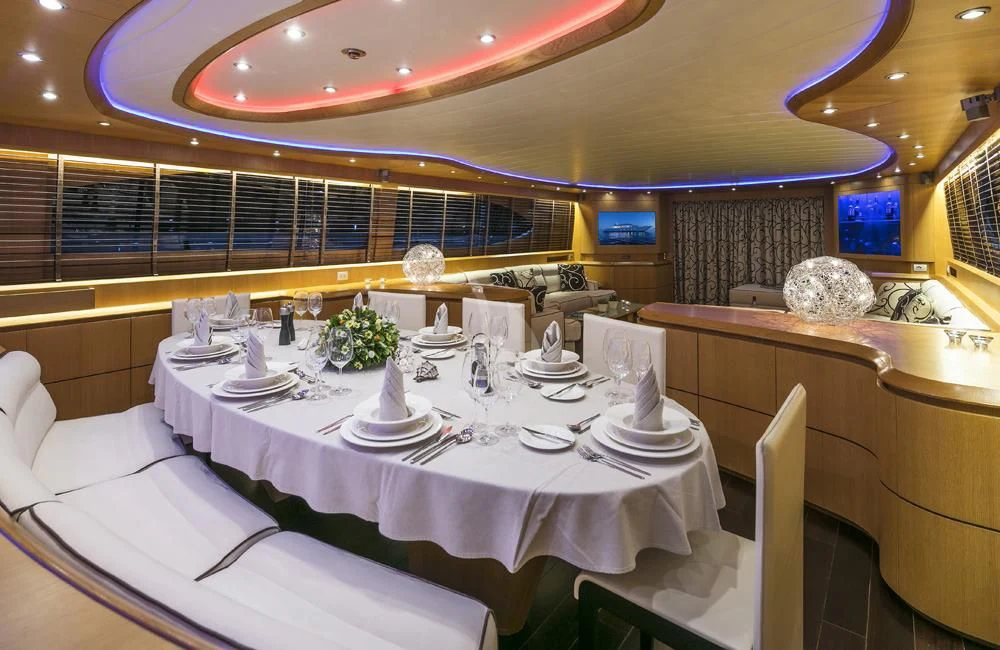 a room with tables and chairs aboard ANASA Yacht for Sale