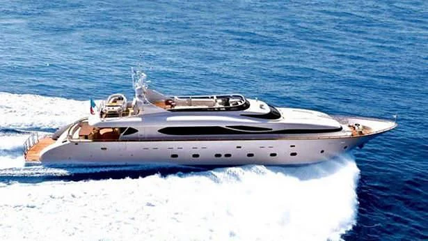 a white yacht with a silver boat on the water aboard ANASA Yacht for Sale