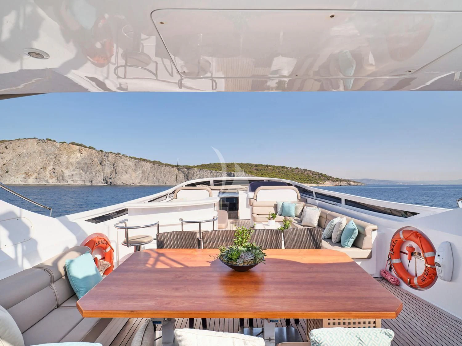 a table on a deck overlooking a body of water aboard ANASA Yacht for Sale