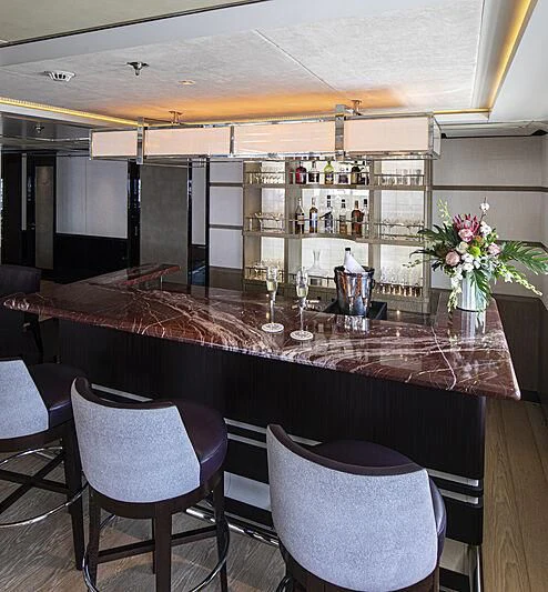 a bar with a table and chairs aboard M5 Yacht for Sale